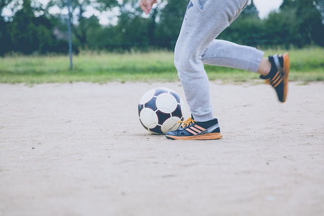 Tva fotter som springer med en fotboll framf;r sig.