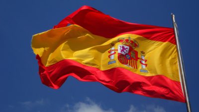 Spaniens flagga som är tre ränder, två röda och en gul i mitten. På den gula randen finns också en bild.