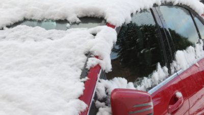 En snötäckt röd bil