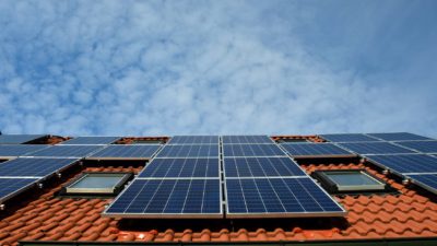 Solceller som satts på en stor platta uppe på ett hustak.