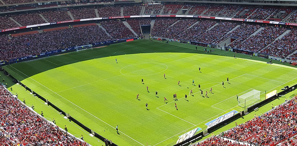 Bild på en fotbollsmatch som pågår på Atletico Madrids hemmaarena "Wanda Metropolian". På läktaren kan man se att de flesta åskådarna har hemmalagets matchtröjor på sig.