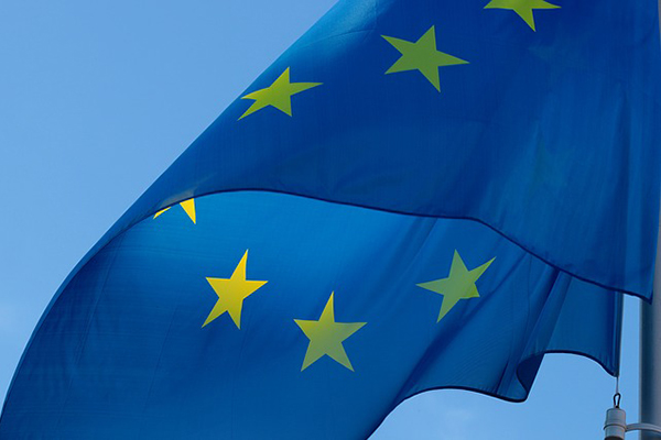 EU:s flagga som blå med gula stjärnor i en ring.