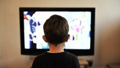 Ett barn som kollar på en tv-skärm