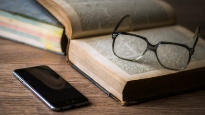 En telefon har lämnats kvar bredvid en uppslagen bok