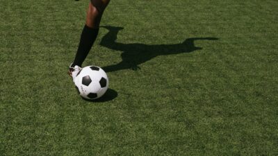 En person som sparkar på en fotboll